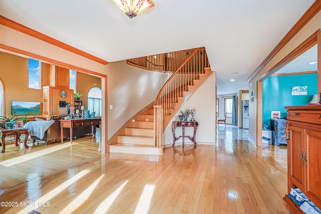 interior space featuring baseboards, ornamental molding, and hardwood / wood-style flooring