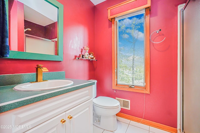 bathroom featuring tile patterned flooring, vanity, toilet, a shower with door, and visible vents