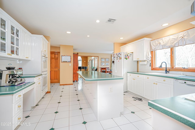 kitchen with a sink, white cabinets, white appliances, and a healthy amount of sunlight