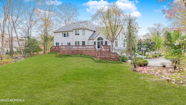 rear view of house with a wooden deck and a yard