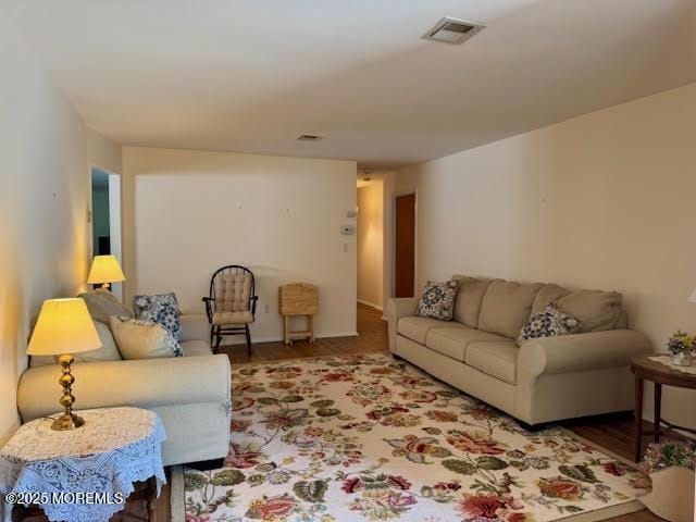 living area with wood finished floors and visible vents