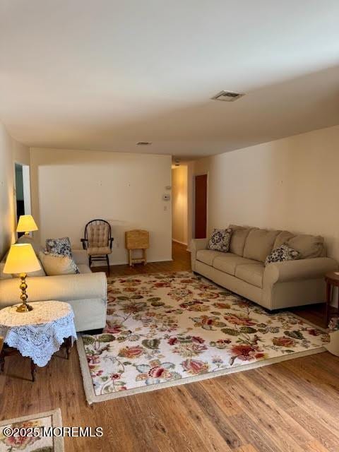 living room featuring visible vents and wood finished floors