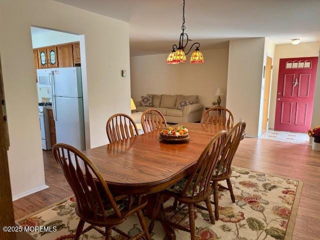 dining space with light wood-style flooring and baseboards