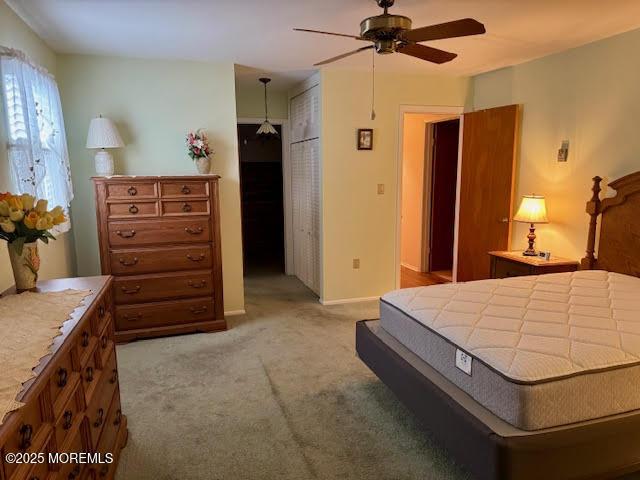 bedroom with baseboards, a ceiling fan, and light colored carpet