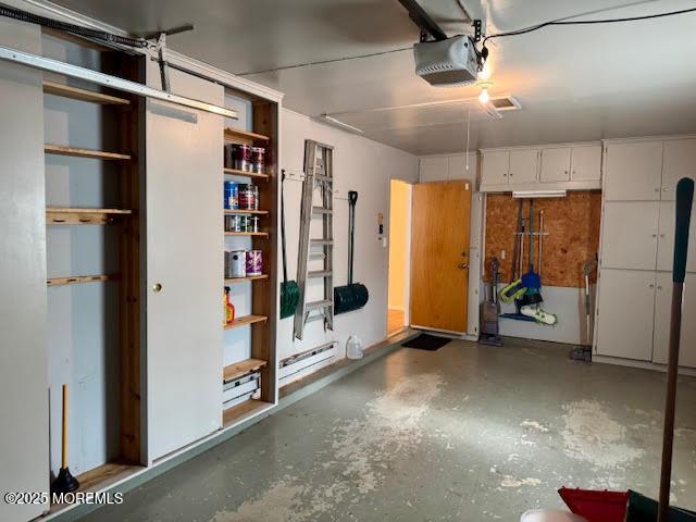 garage featuring baseboard heating and a garage door opener