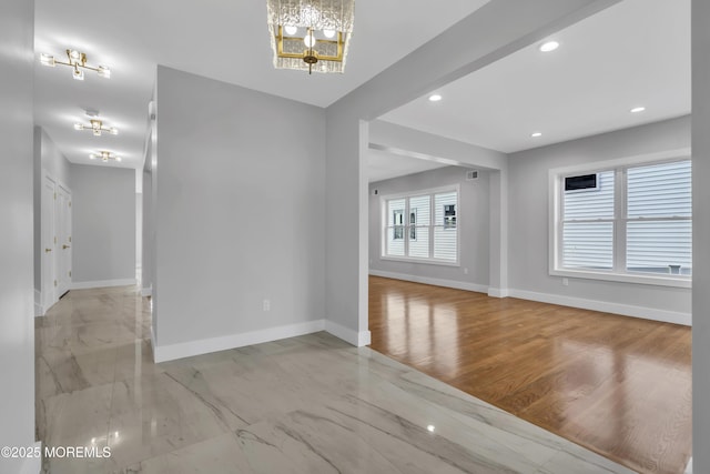 unfurnished room featuring recessed lighting, a notable chandelier, and baseboards