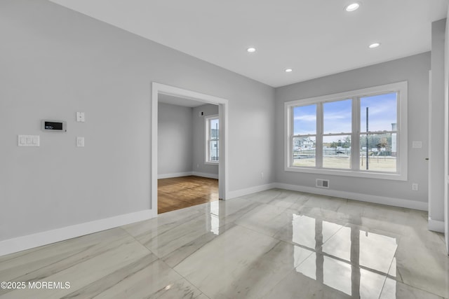 spare room with recessed lighting, marble finish floor, visible vents, and baseboards