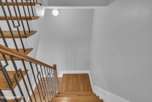 staircase with wood finished floors and baseboards