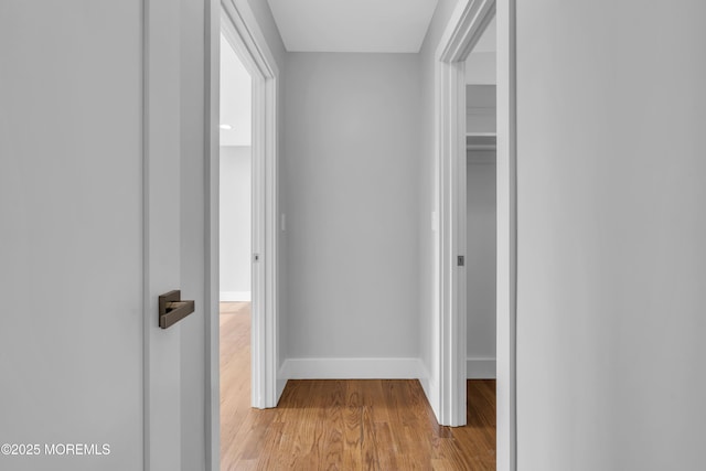 hall with baseboards and light wood-style floors