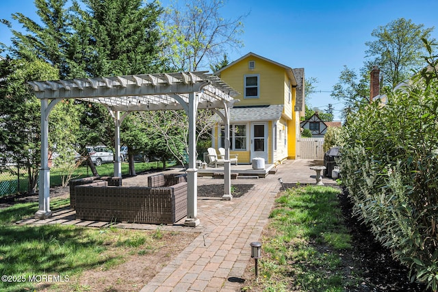 rear view of property with fence, a pergola, and a patio area
