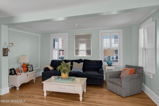 living room with crown molding, light wood-style floors, and baseboards