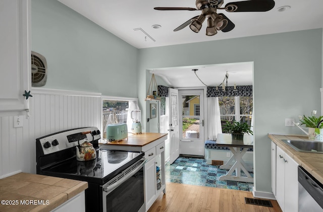 kitchen with ceiling fan, visible vents, white cabinets, stainless steel appliances, and light wood-style flooring