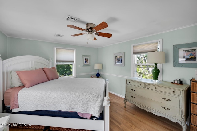 bedroom featuring visible vents, multiple windows, and light wood finished floors