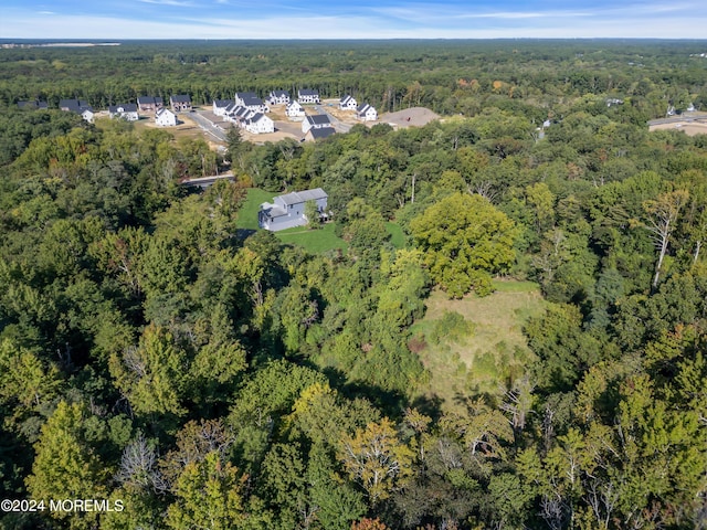 birds eye view of property featuring a view of trees