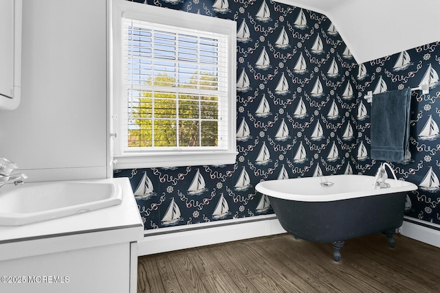 full bathroom featuring a soaking tub, wallpapered walls, and wood finished floors