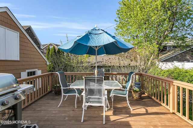 wooden deck featuring area for grilling and outdoor dining area