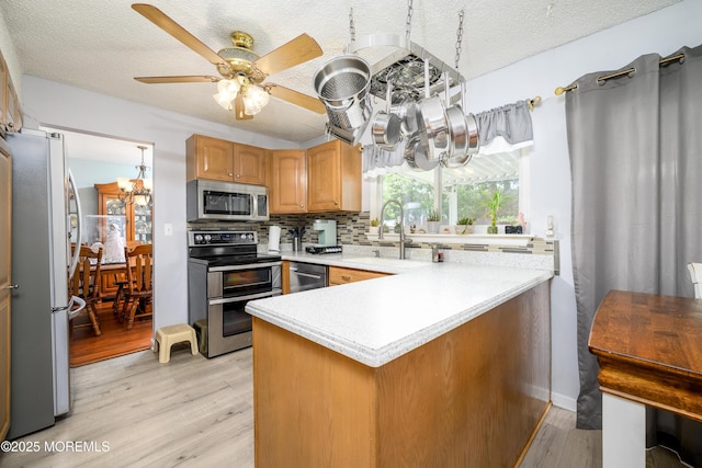 102 Buckingham Dr, Jackson, NJ 08527 - kitchen with appliances with stainless steel finishes, a sink, a peninsula, light wood-style floors, and light countertops