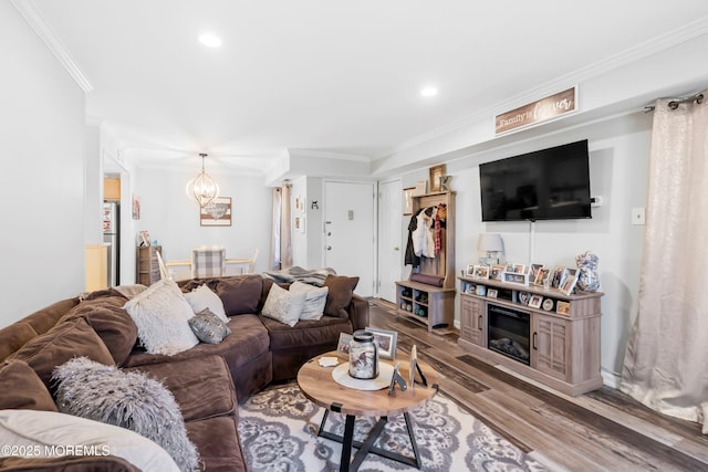 living area featuring recessed lighting, a chandelier, ornamental molding, and wood finished floors