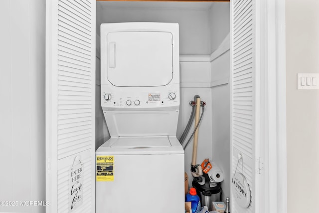 washroom featuring stacked washer / drying machine and laundry area