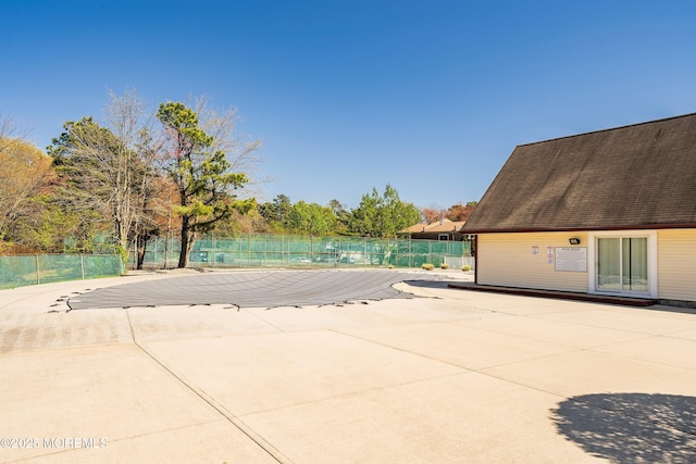 view of swimming pool featuring a patio and fence