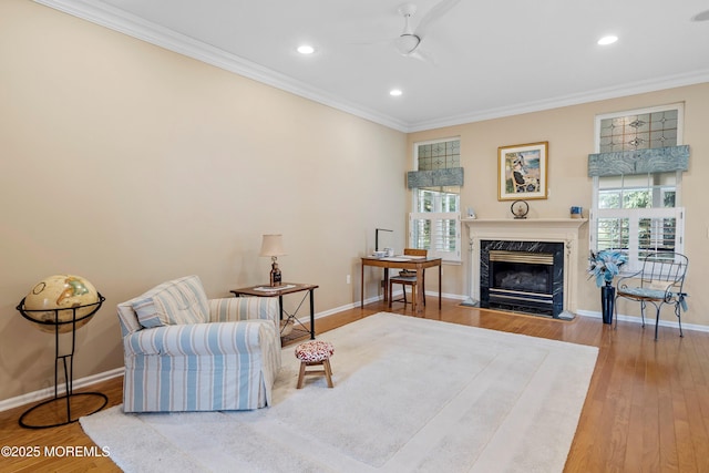 living area featuring crown molding, healthy amount of natural light, wood finished floors, ceiling fan, and recessed lighting