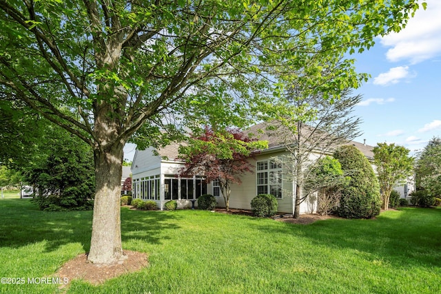 view of grassy yard with a sunroom
