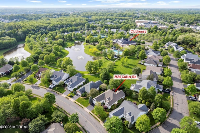 aerial view of residential area with a nearby body of water and a forest