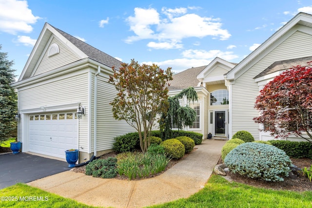 view of front of house featuring driveway and a shingled roof