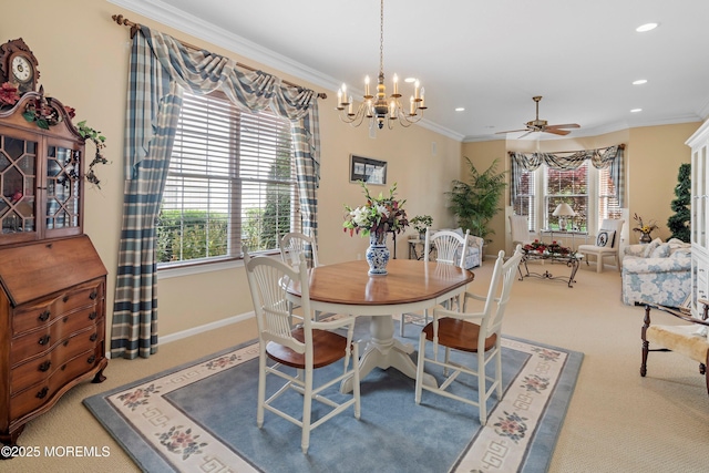 carpeted dining space featuring crown molding, ceiling fan, baseboards, a chandelier, and recessed lighting