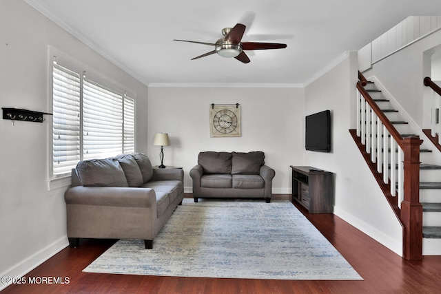 living room featuring ornamental molding, baseboards, stairway, dark wood-type flooring, and a ceiling fan