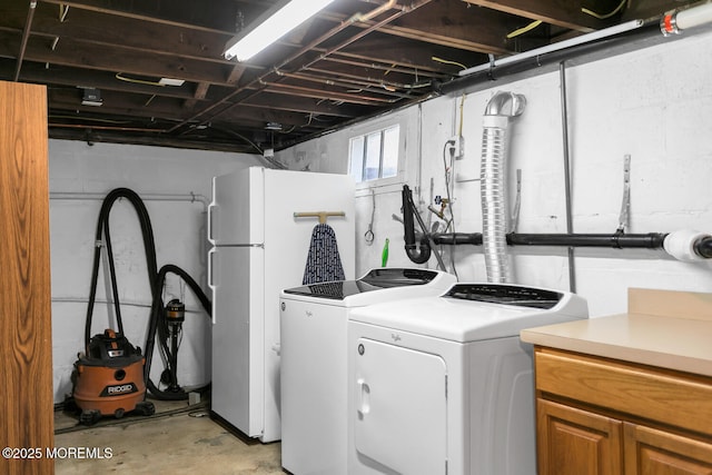 clothes washing area featuring washer and clothes dryer and cabinet space