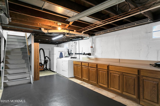 basement featuring independent washer and dryer, freestanding refrigerator, and stairway