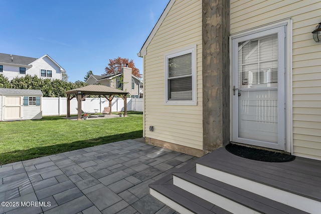 entrance to property with a patio area, fence, and a yard