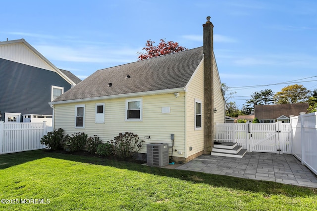 back of property featuring a lawn, central AC unit, a gate, a patio area, and a fenced backyard