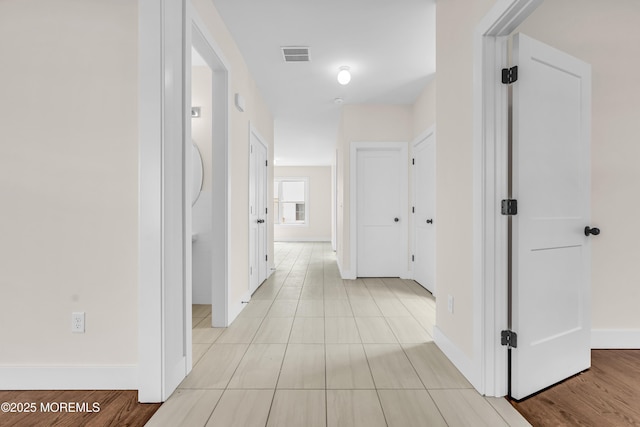 hall with visible vents and baseboards