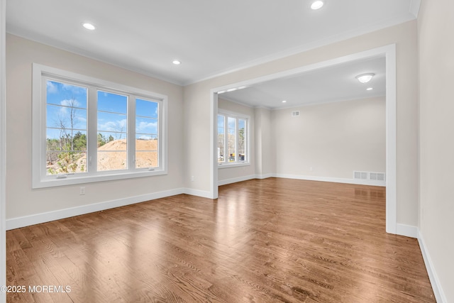 spare room with recessed lighting, visible vents, baseboards, ornamental molding, and wood finished floors