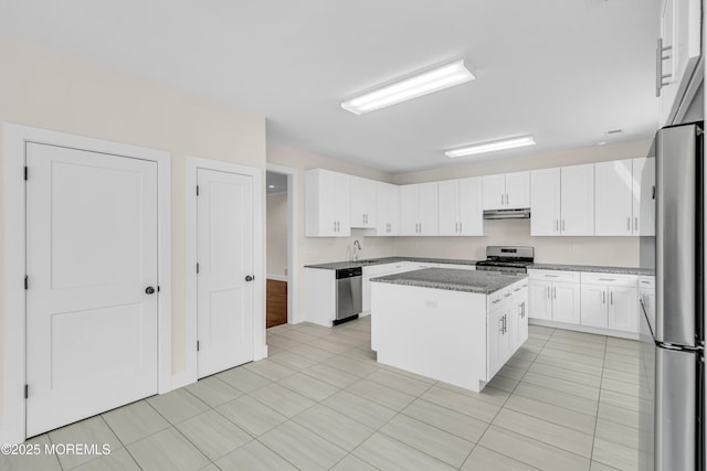 kitchen featuring a sink, under cabinet range hood, a center island, white cabinetry, and appliances with stainless steel finishes