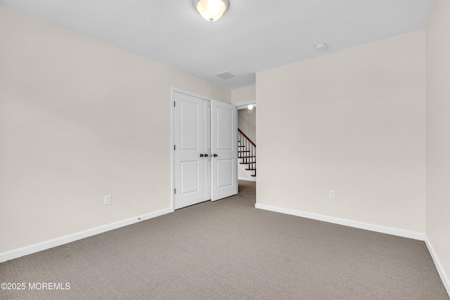 carpeted spare room featuring baseboards