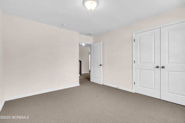 unfurnished bedroom with baseboards, visible vents, a closet, and carpet