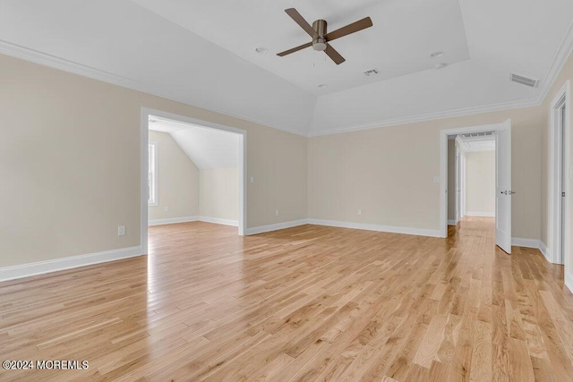 interior space with a ceiling fan, visible vents, lofted ceiling, ornamental molding, and light wood-style flooring