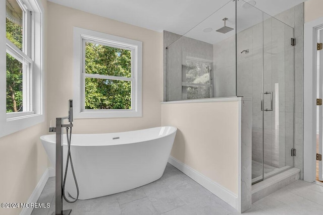 bathroom featuring baseboards, a freestanding bath, and a stall shower