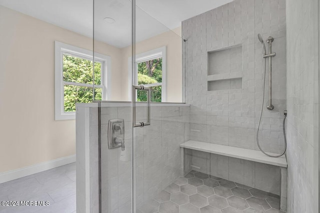 bathroom featuring tile patterned floors, a shower stall, and baseboards