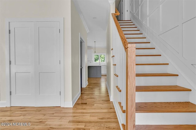 staircase featuring baseboards and wood finished floors