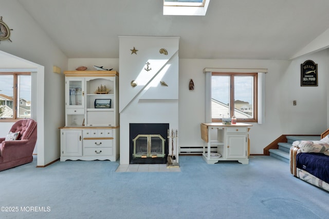living room featuring baseboard heating, carpet, a fireplace with flush hearth, stairway, and vaulted ceiling with skylight
