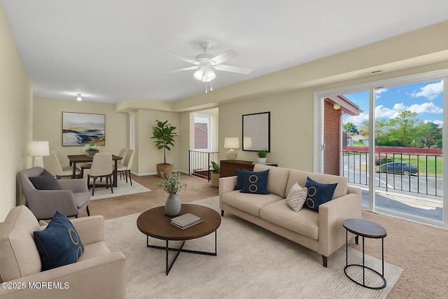 living area with light colored carpet, a ceiling fan, and visible vents
