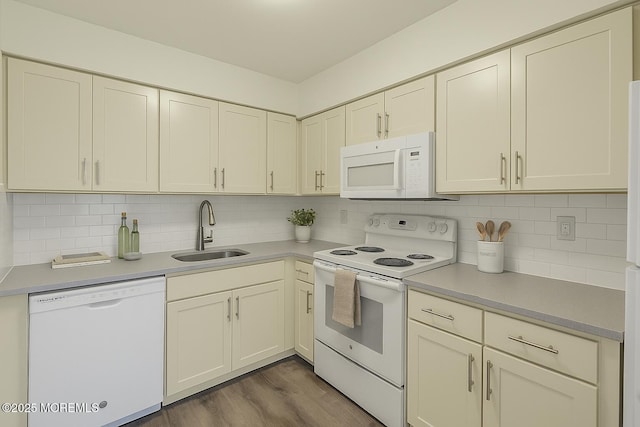 kitchen featuring a sink, white appliances, light countertops, dark wood finished floors, and backsplash