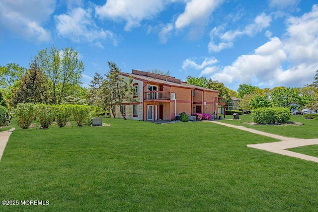 rear view of property featuring a lawn