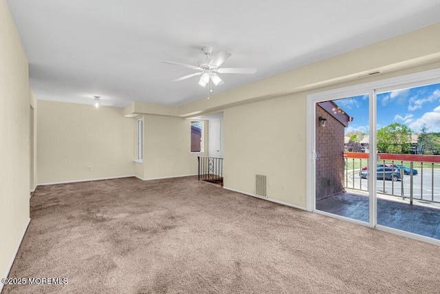 empty room featuring baseboards, carpet, ceiling fan, and visible vents