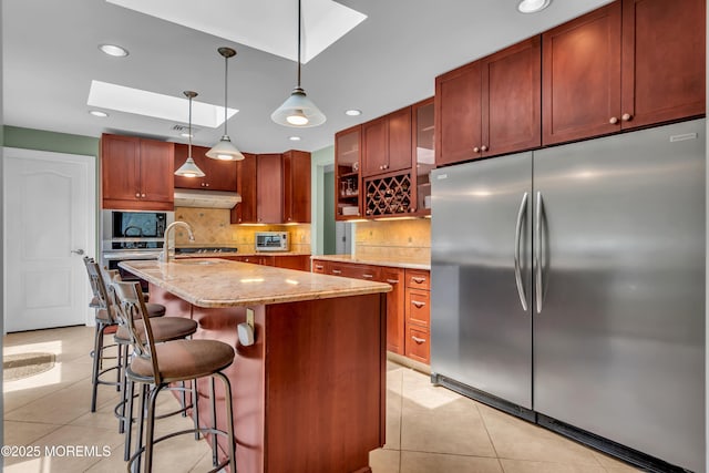86 Cox Cro Rd, Toms River, NJ 08755 - kitchen featuring light tile patterned flooring, light stone countertops, built in appliances, backsplash, and a skylight