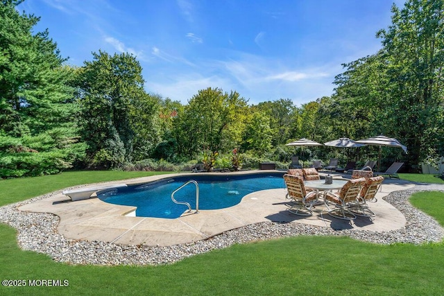 outdoor pool with a patio, a diving board, and a lawn